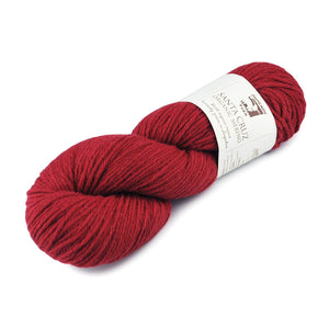 A skein of saffron coloured Santa Cruz  yarn shown in a full skein. 